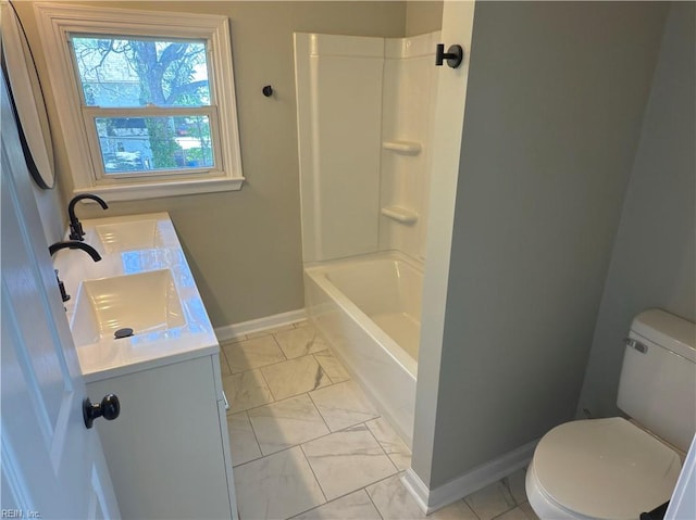 full bath with toilet, double vanity, marble finish floor, and a sink