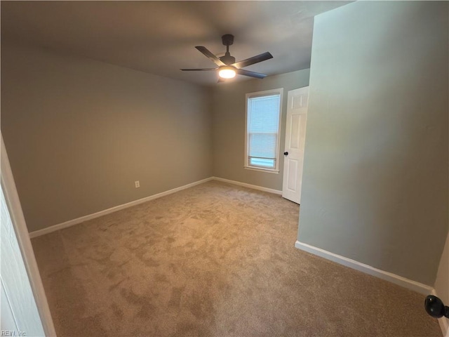 carpeted spare room with baseboards and ceiling fan