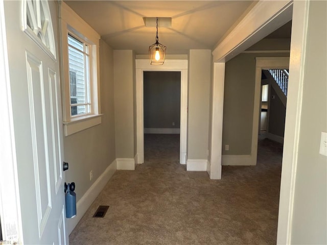carpeted entrance foyer featuring baseboards and visible vents