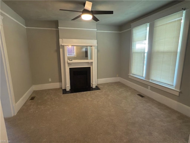 unfurnished living room with visible vents, baseboards, a ceiling fan, carpet, and a fireplace with flush hearth