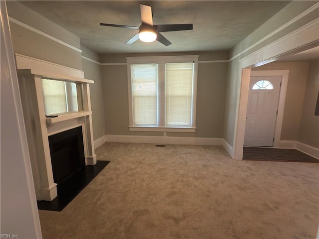 unfurnished living room featuring a fireplace with flush hearth, baseboards, a ceiling fan, and carpet floors