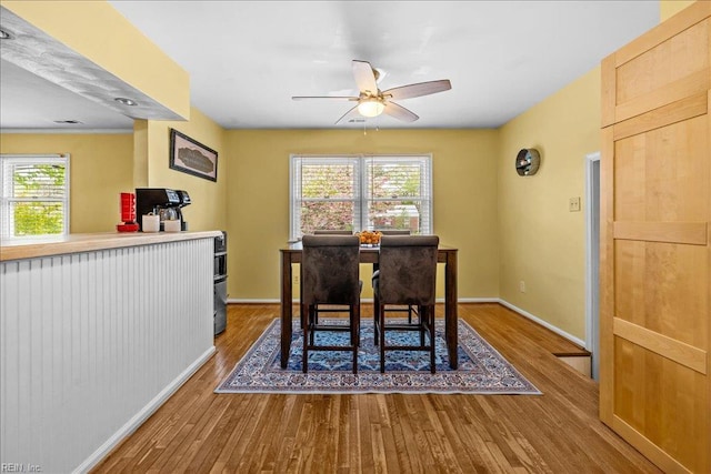 dining room featuring baseboards, wood finished floors, and ceiling fan