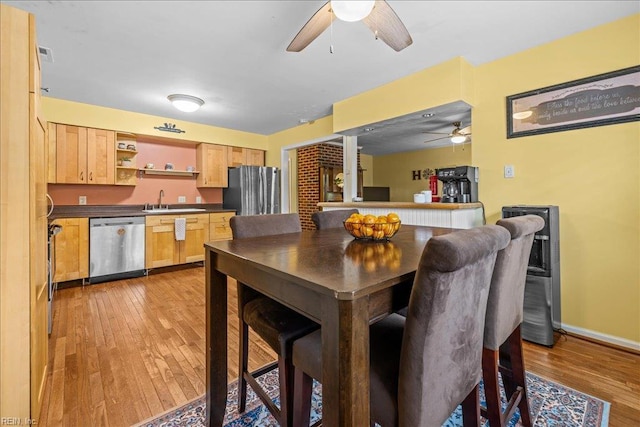 dining area with baseboards, a ceiling fan, and light wood-style floors