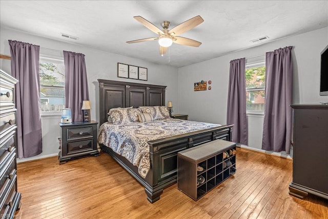 bedroom with light wood-style floors, ceiling fan, baseboards, and visible vents