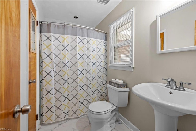 bathroom featuring a sink, toilet, marble finish floor, and baseboards