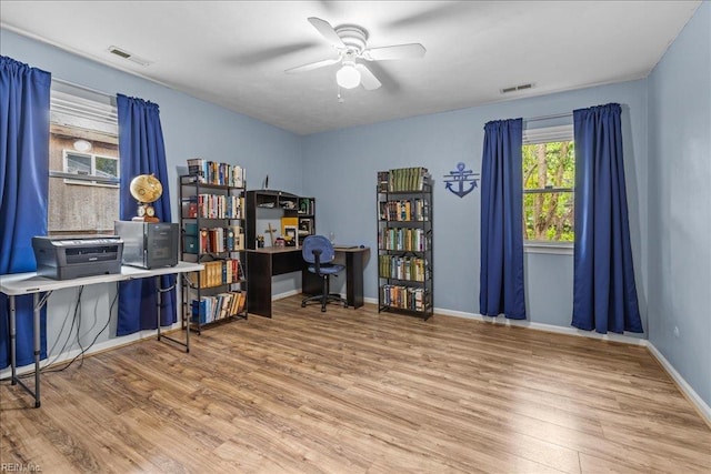 home office with visible vents, baseboards, a ceiling fan, and wood finished floors