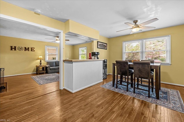 dining area with ceiling fan, hardwood / wood-style flooring, and baseboards