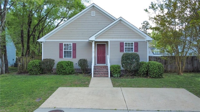 bungalow featuring entry steps, a front yard, and fence