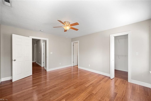 interior space featuring visible vents, a spacious closet, light wood-style floors, and baseboards