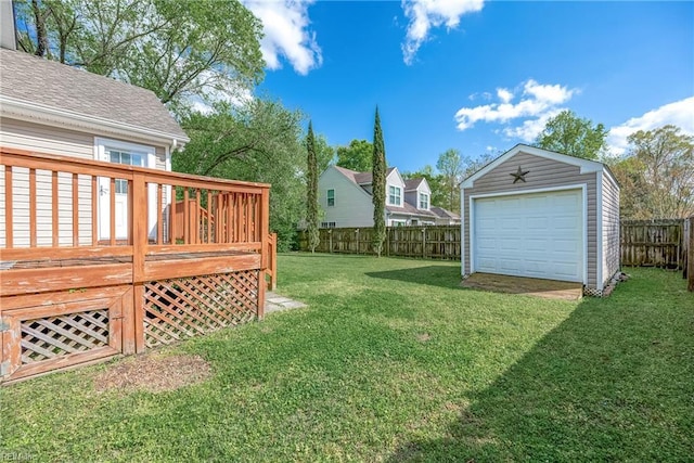 view of yard with a fenced backyard, a detached garage, a deck, and an outdoor structure