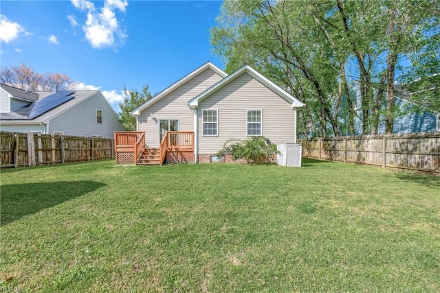 rear view of property with a fenced backyard, a wooden deck, a lawn, and crawl space