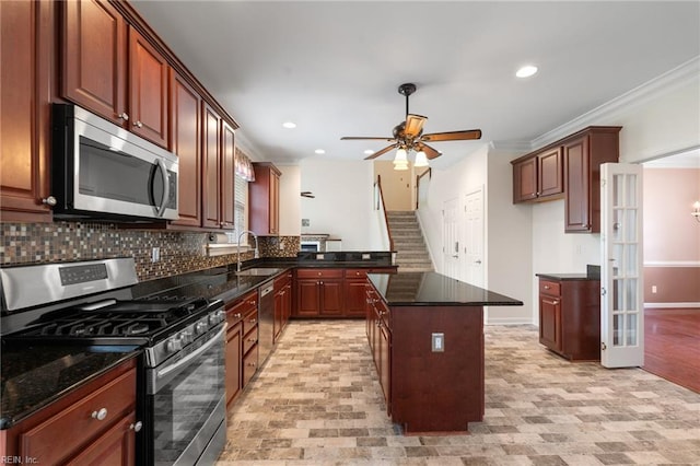 kitchen with a sink, backsplash, crown molding, and stainless steel appliances