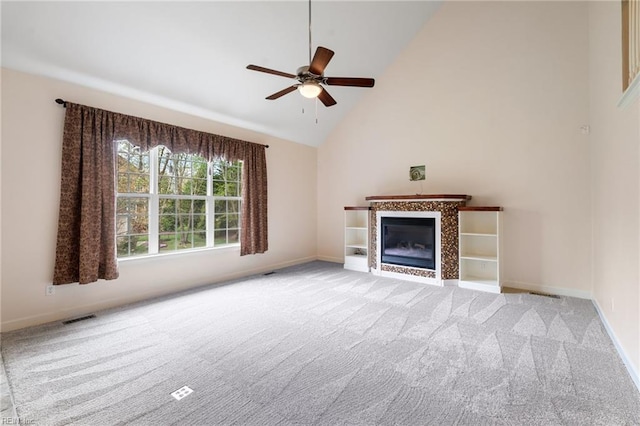 unfurnished living room featuring visible vents, a tiled fireplace, a ceiling fan, high vaulted ceiling, and light colored carpet