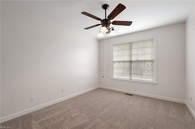 carpeted empty room featuring visible vents, baseboards, and a ceiling fan