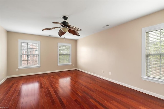 unfurnished room with wood finished floors, ceiling fan, and a wealth of natural light