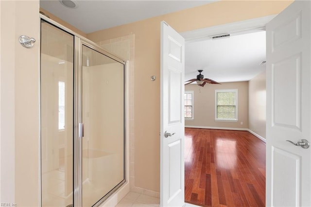 bathroom featuring baseboards, a shower stall, visible vents, ceiling fan, and wood finished floors