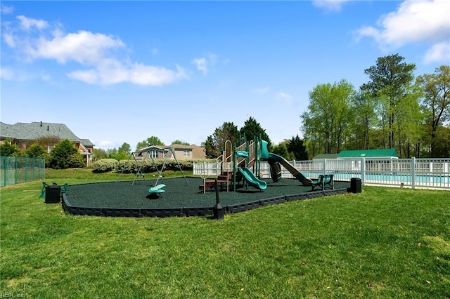 community play area with a community pool, fence, and a lawn