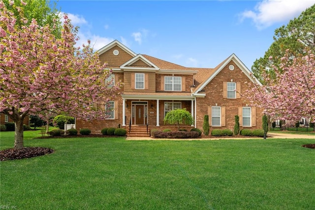 craftsman-style house featuring a front yard and brick siding