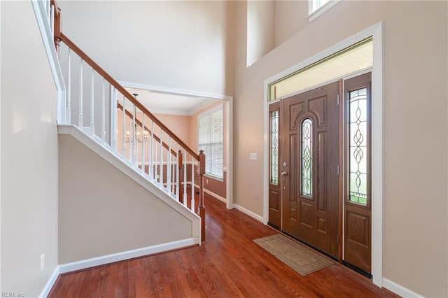 foyer entrance with wood finished floors, a wealth of natural light, and stairs