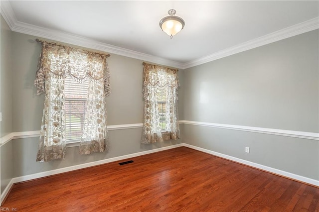 spare room with wood finished floors, baseboards, and plenty of natural light