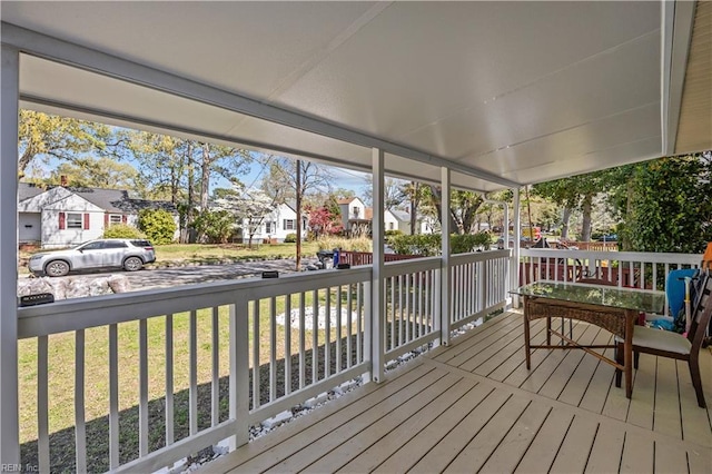 wooden deck featuring a residential view, a porch, and a yard