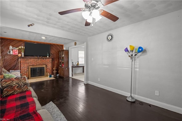 living room with a fireplace, baseboards, wood finished floors, and ceiling fan