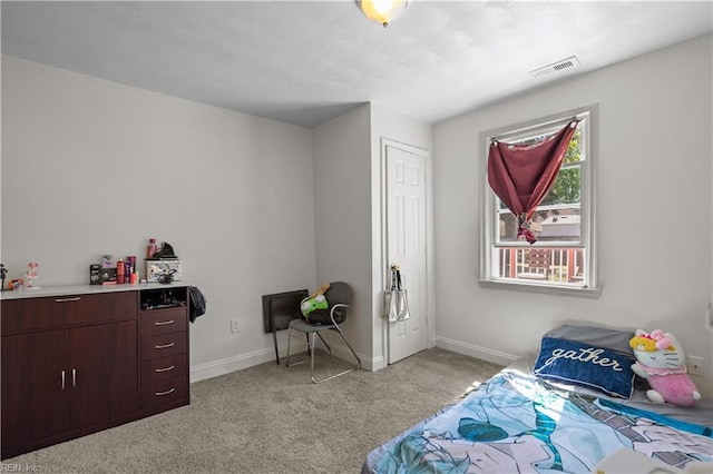 bedroom with light carpet, visible vents, and baseboards