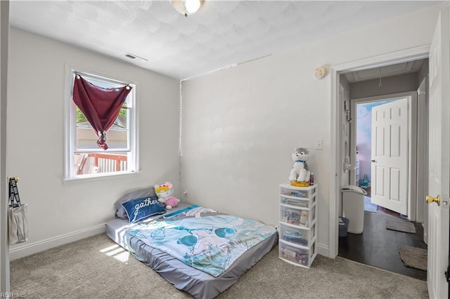 carpeted bedroom with attic access, baseboards, and visible vents