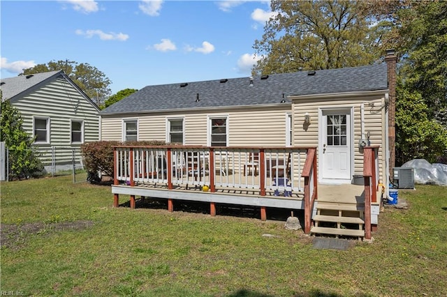 rear view of house featuring central AC unit, a yard, a chimney, fence, and roof with shingles