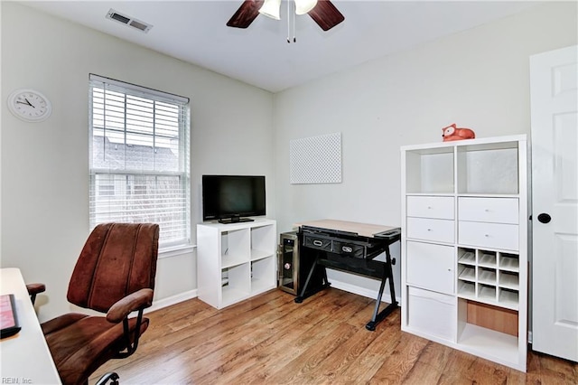 office space featuring visible vents, baseboards, wood finished floors, and ceiling fan