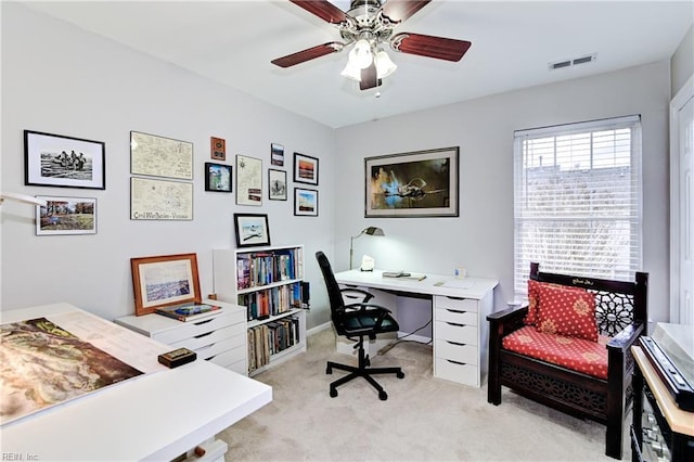 office area with visible vents, ceiling fan, and light carpet