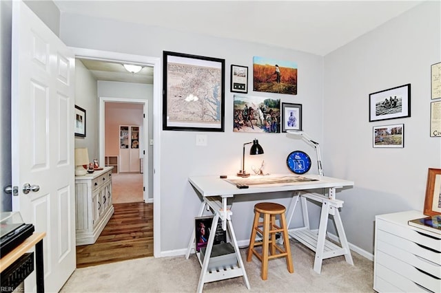 home office featuring light carpet and baseboards