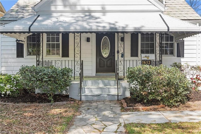 view of exterior entry featuring covered porch