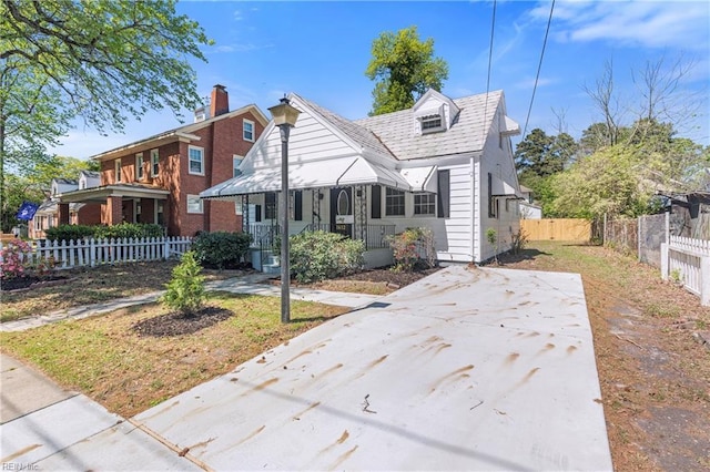 bungalow-style house featuring a chimney and fence