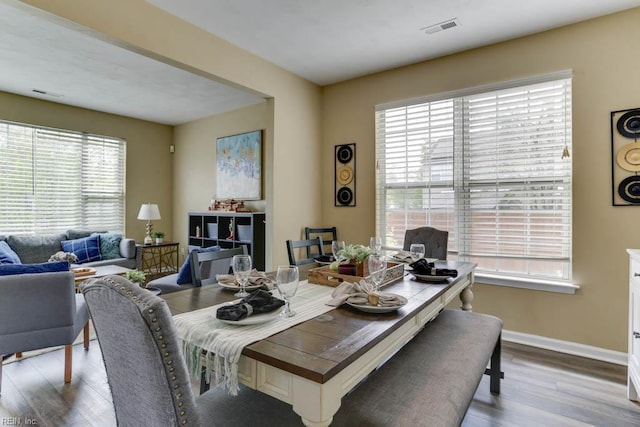 dining area featuring visible vents, a wealth of natural light, wood finished floors, and baseboards