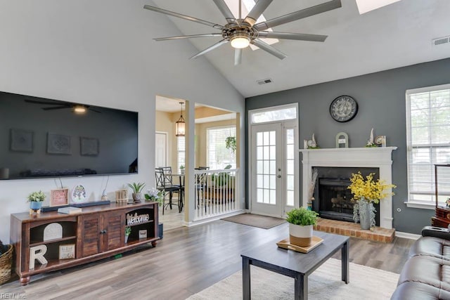 living area featuring visible vents, ceiling fan, wood finished floors, and a healthy amount of sunlight