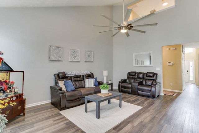 living room with wood finished floors, high vaulted ceiling, ceiling fan, and baseboards