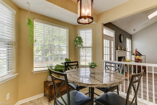 dining space with a wealth of natural light, baseboards, and a fireplace