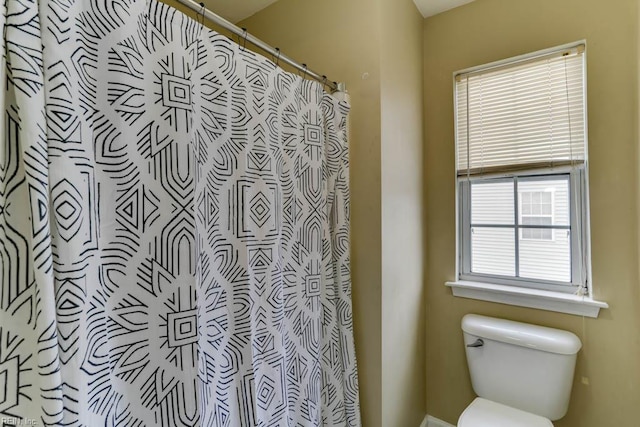 bathroom with toilet and a shower with shower curtain