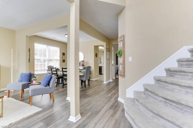interior space with light wood-type flooring, baseboards, and stairway