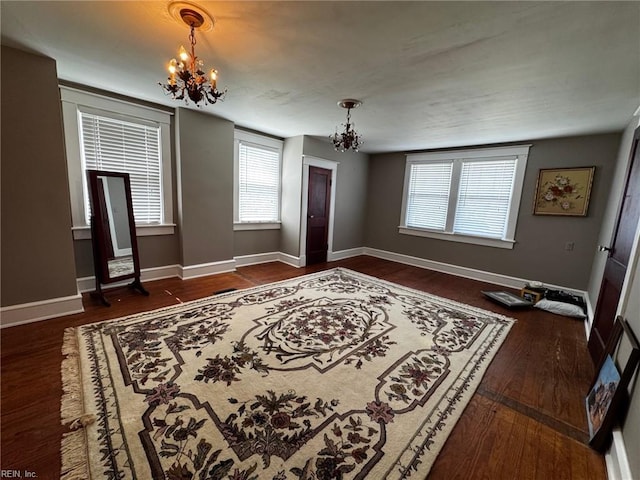 entryway featuring a notable chandelier, baseboards, and wood finished floors