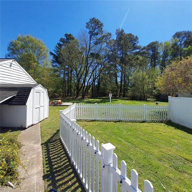 view of yard with an outbuilding, fence private yard, and a storage unit
