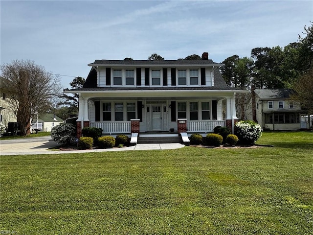 view of front of house featuring brick siding, a front lawn, and covered porch