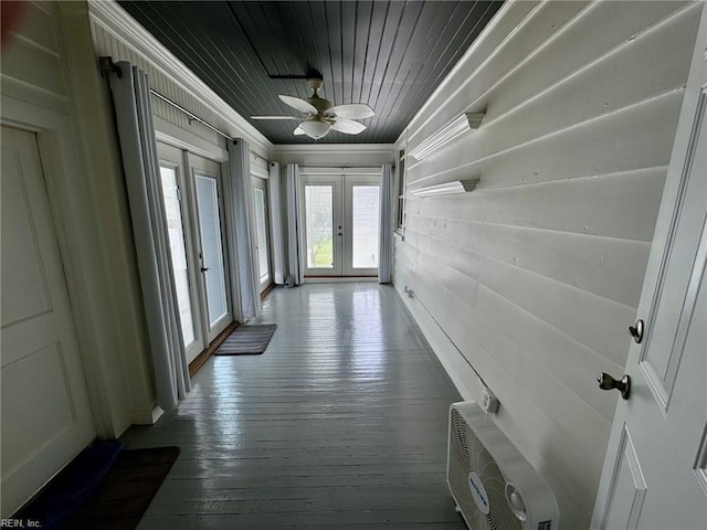 corridor with ornamental molding, wooden walls, french doors, wood ceiling, and hardwood / wood-style flooring