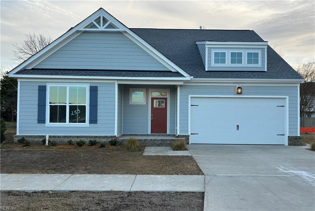 view of front of home with a garage, driveway, and roof with shingles