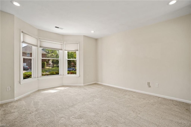spare room featuring visible vents, baseboards, recessed lighting, and carpet floors