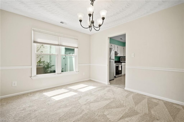 spare room featuring a chandelier, visible vents, light colored carpet, and baseboards