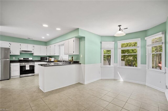 kitchen featuring white cabinetry, dark countertops, and stainless steel appliances