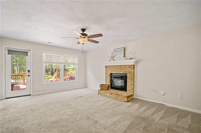 unfurnished living room with baseboards, carpet flooring, a ceiling fan, a brick fireplace, and visible vents