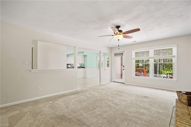 carpeted spare room with baseboards and ceiling fan